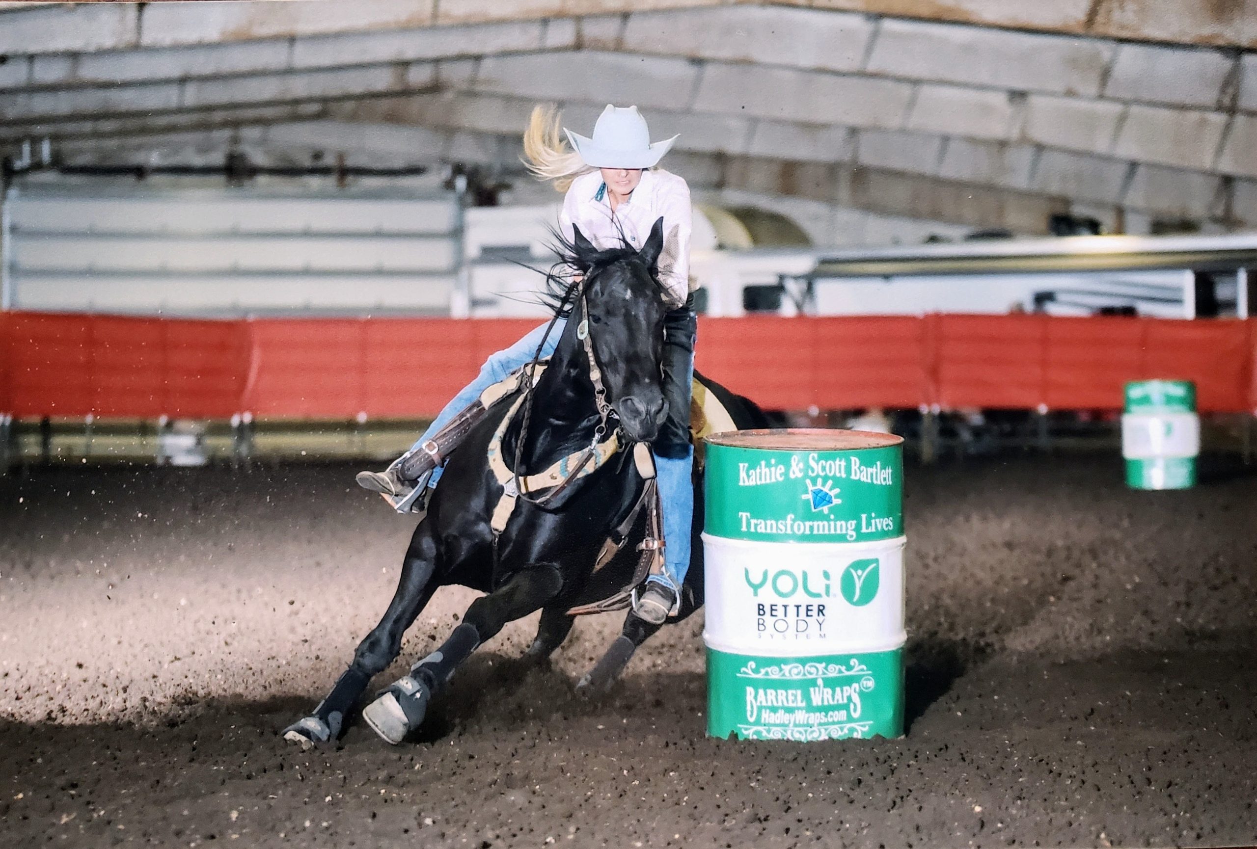 Shari Kennedy running barrels on a black horse
